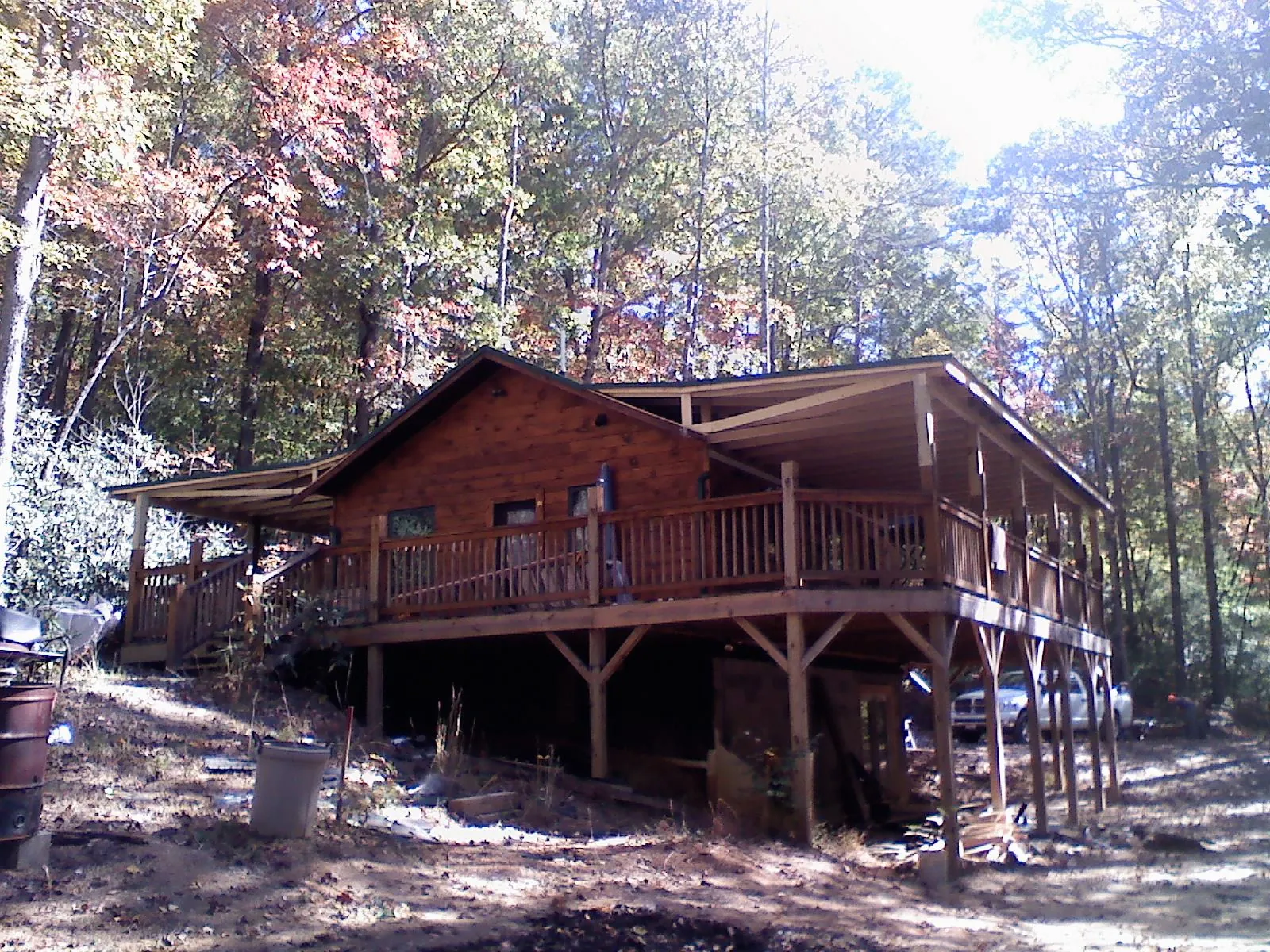 Log cabin with a wraparound porch and metal roof in the fall in Atlantic Beach
